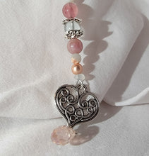 Load image into Gallery viewer, Artisan designed and handcrafted loose leaf tea ball infuser decorated with precious pink and white bead and a beautiful silver colour scroll heart  charm. This tea infuser add bling to your tea cup or mug as your loose leaf tea steeps.
