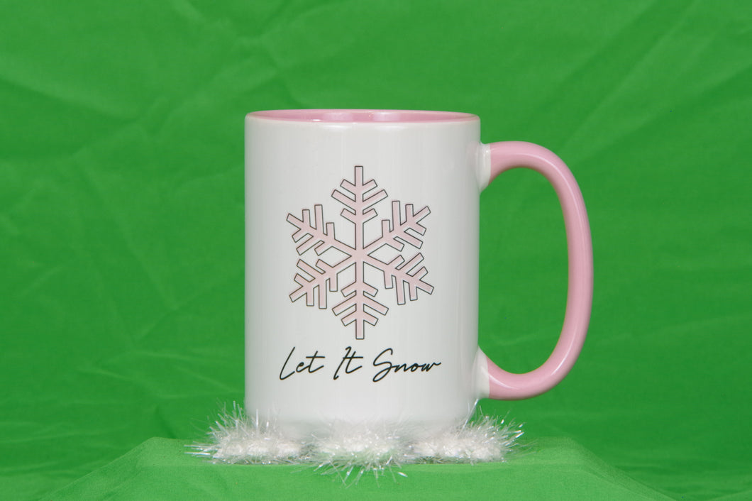 White mug with pink handle and interior. Light pink graphic of snowflake outlined in black and the words Let It Snow in black writing. A nice large mug for tea.