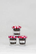 Load image into Gallery viewer, Three small jars with red and white checked lids containing black loose leaf teas of Buckingham Palace, Lovers Leap, and Icewine.  This is one option of the Mini Tea Tree set.
