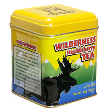 Load image into Gallery viewer, Yellow metal box with a black moose in blue water in front of green mountains with white peaks. Container contains 12 tea bags of Wilderness Huckleberry tea.
